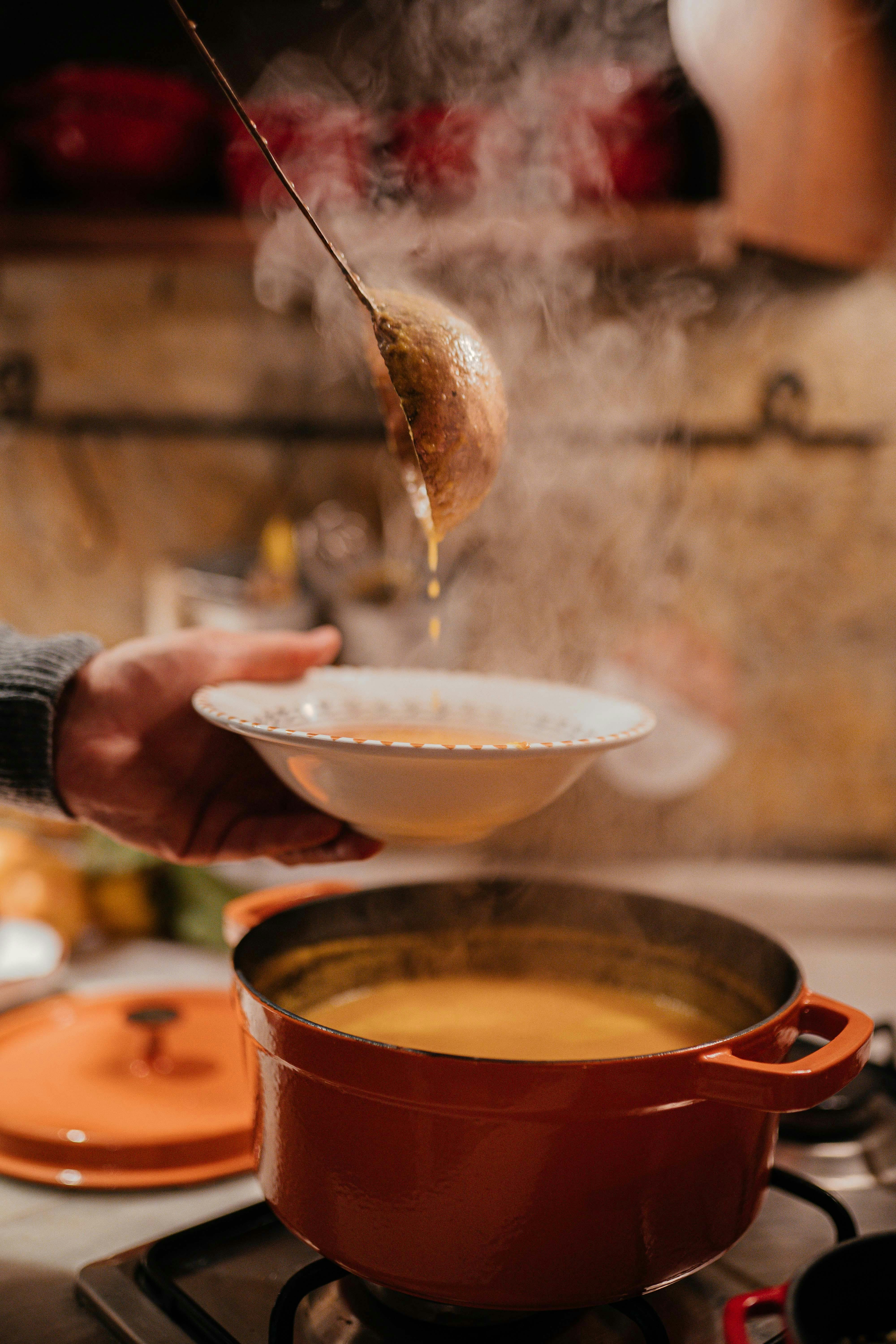 Steamy bowl of hot soup being served in a cozy kitchen setting.