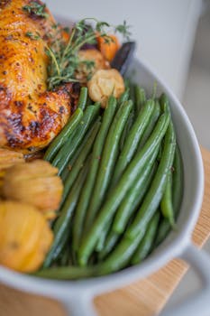 Delicious roasted chicken served with green beans and aromatic herbs.