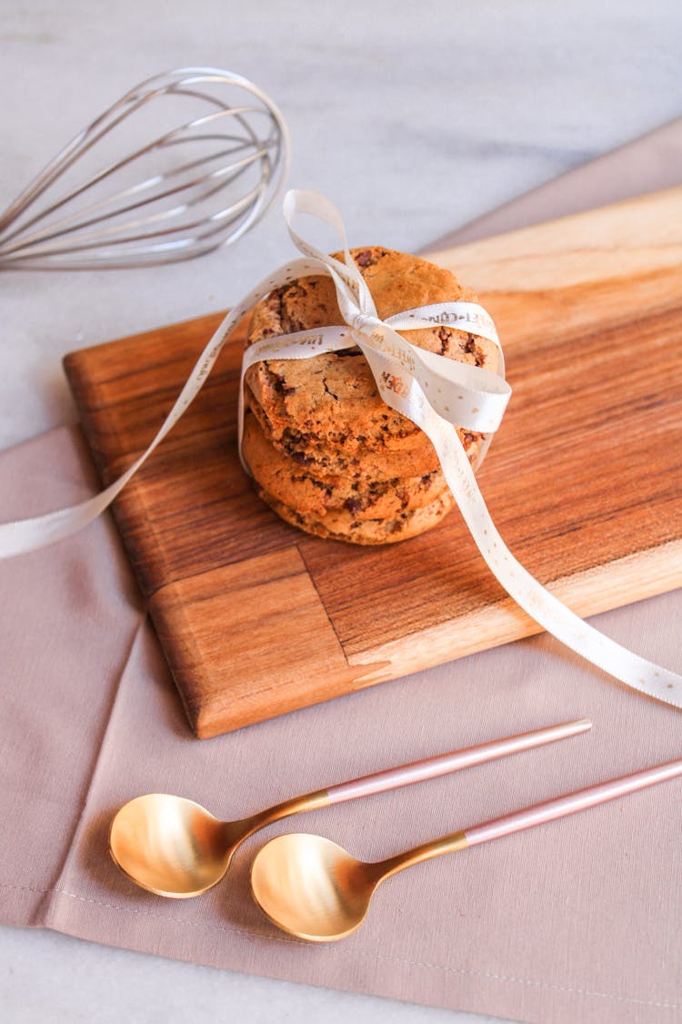 Stack Of Cookies Tied With Ribbon On Wooden Cutting Board