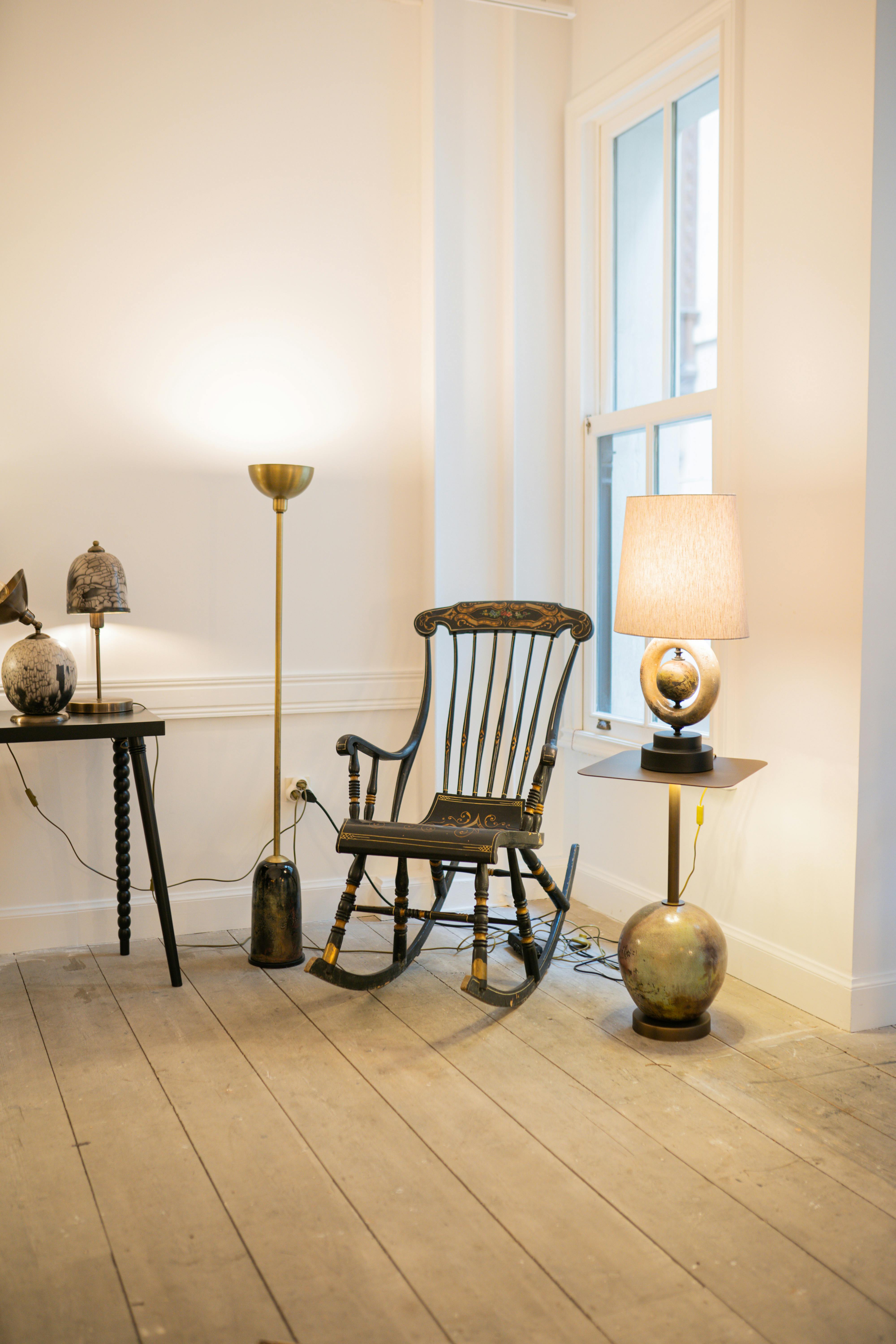 Free Warm, inviting living room featuring vintage decor with an antique chair and lamps. Stock Photo