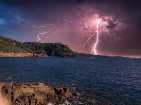 Intense lightning strike illuminates the coastline of Livorno, Tuscany, Italy during a dramatic thunderstorm.