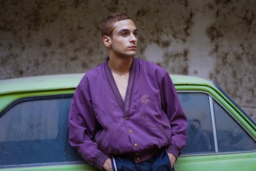 Portrait of Man in Purple Shirt Leaning on Green Car