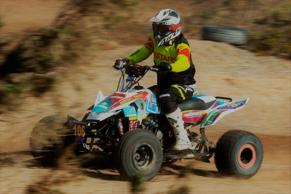 Action-packed scene of an ATV racing on a dirt track, showcasing the thrill of motorsports.