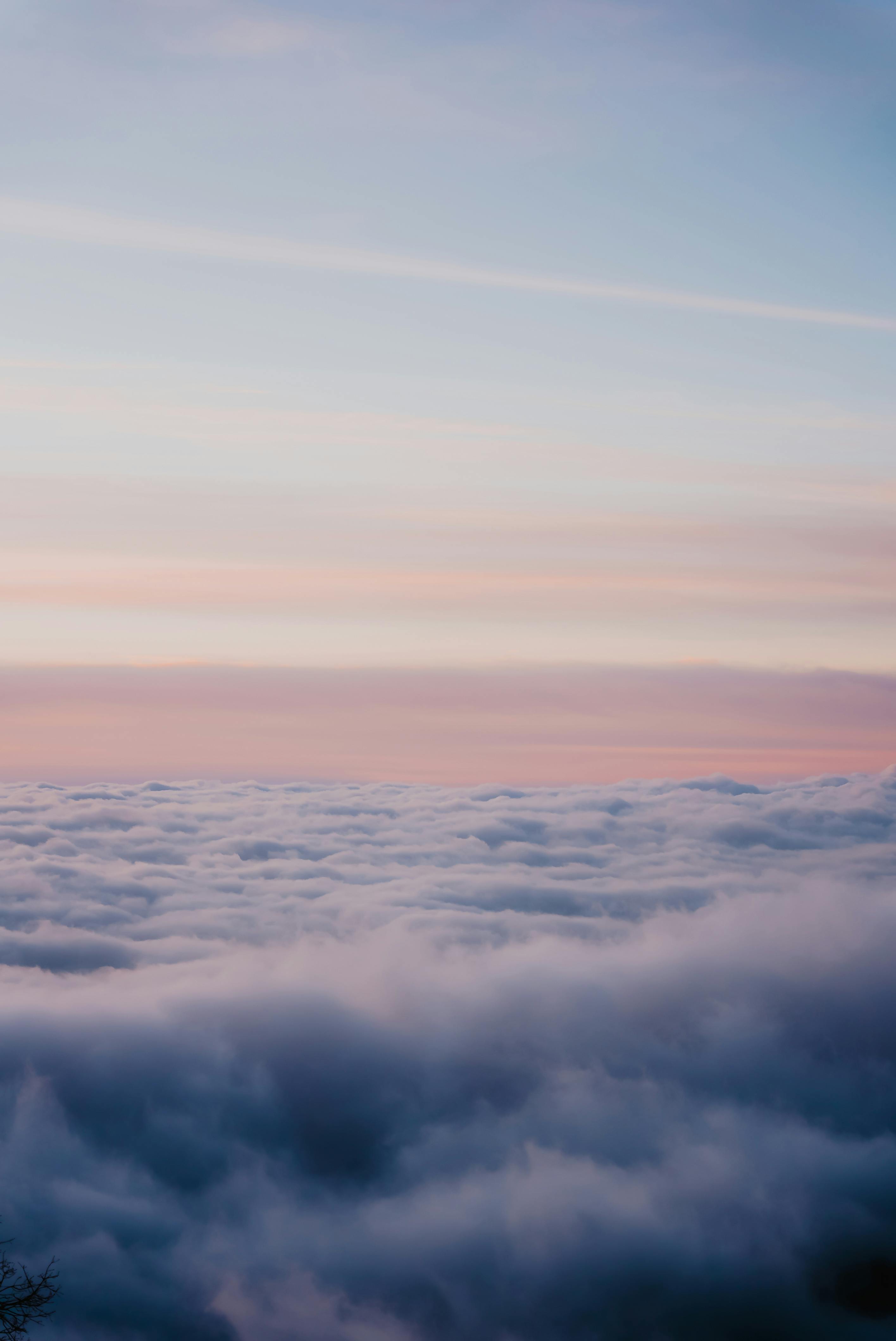 A breathtaking view above the clouds with a serene sunset sky, perfect for relaxation and inspiration.