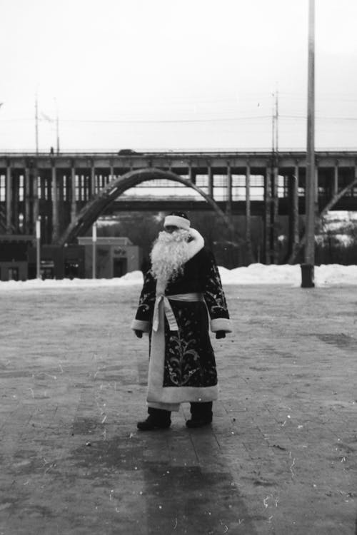 Black and White Photo of Santa Claus Standing in Empty Square