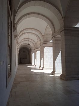 A beautiful stone archway with elegant design, illuminated by sunlight casting intricate shadows.
