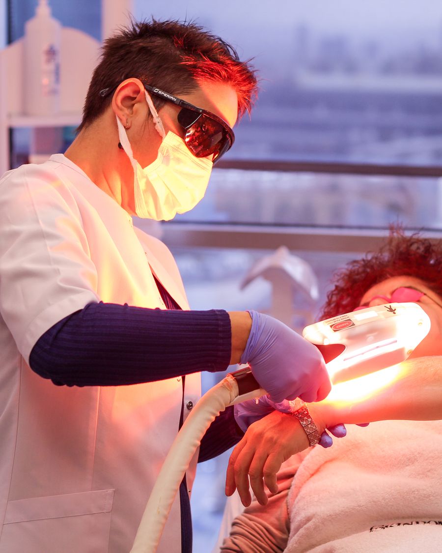 Clinician performing light-based therapy treatment on a patient in a clinical setting