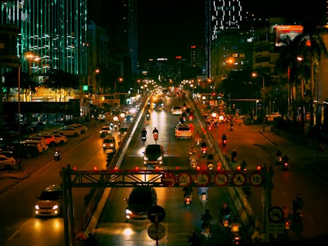 Vibrant night scene of bustling traffic under city lights in Hanoi, Vietnam.