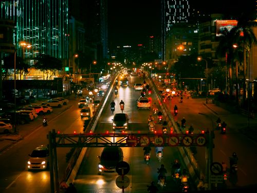 Free Vibrant night scene of bustling traffic under city lights in Hanoi, Vietnam. Stock Photo
