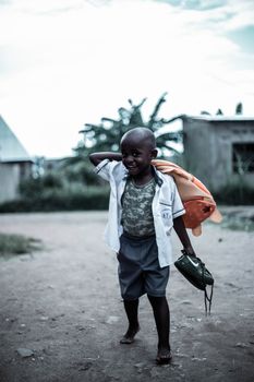 Smiling child walking barefoot outdoors with a backpack, showcasing joy and innocence.