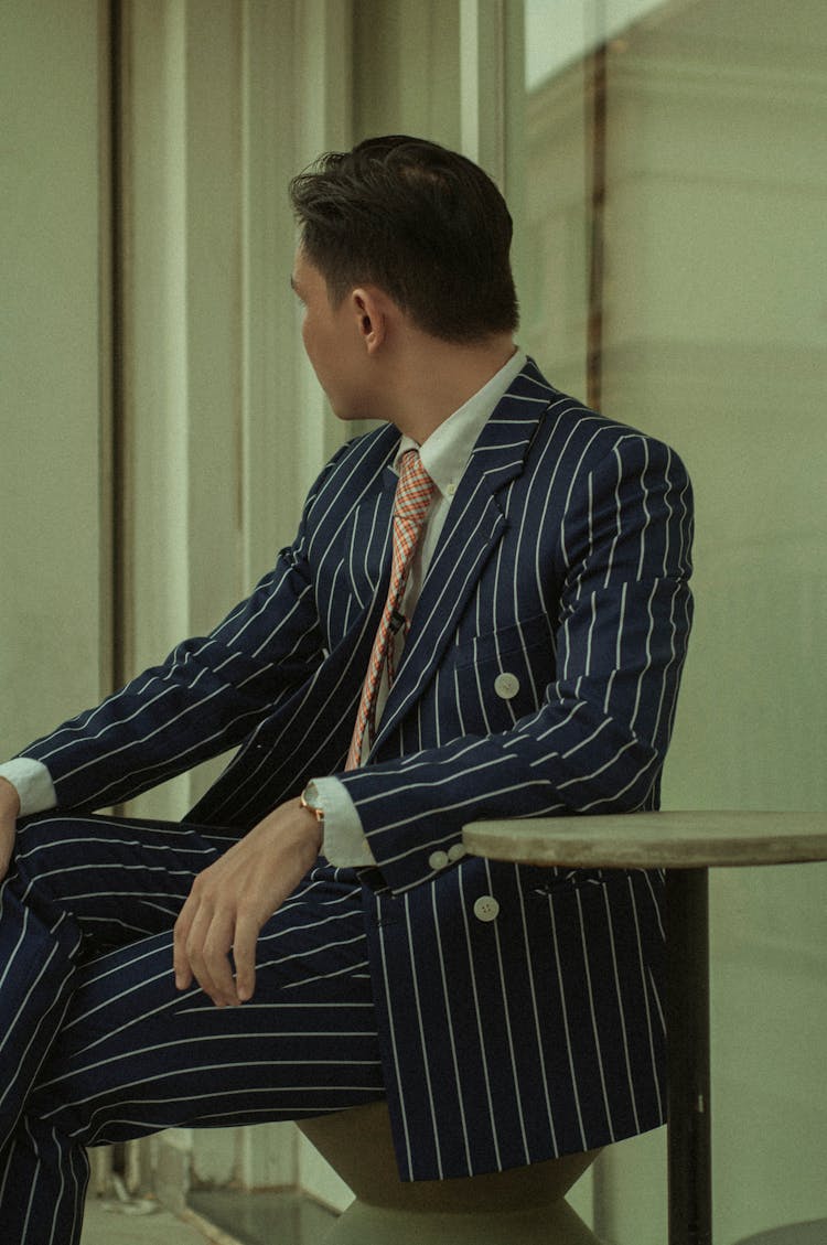 Man In Pinstriped Suit Sitting At Table