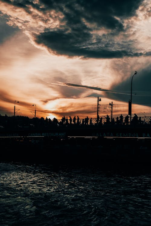 Silhouette of People Walking on Bridge during Sunset