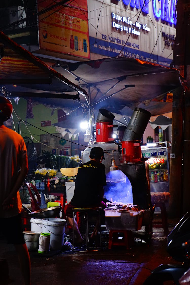 Man Grilling In Front Of Food Stall