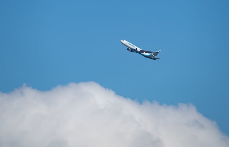 White And Blue Airplane Flying In The Sky