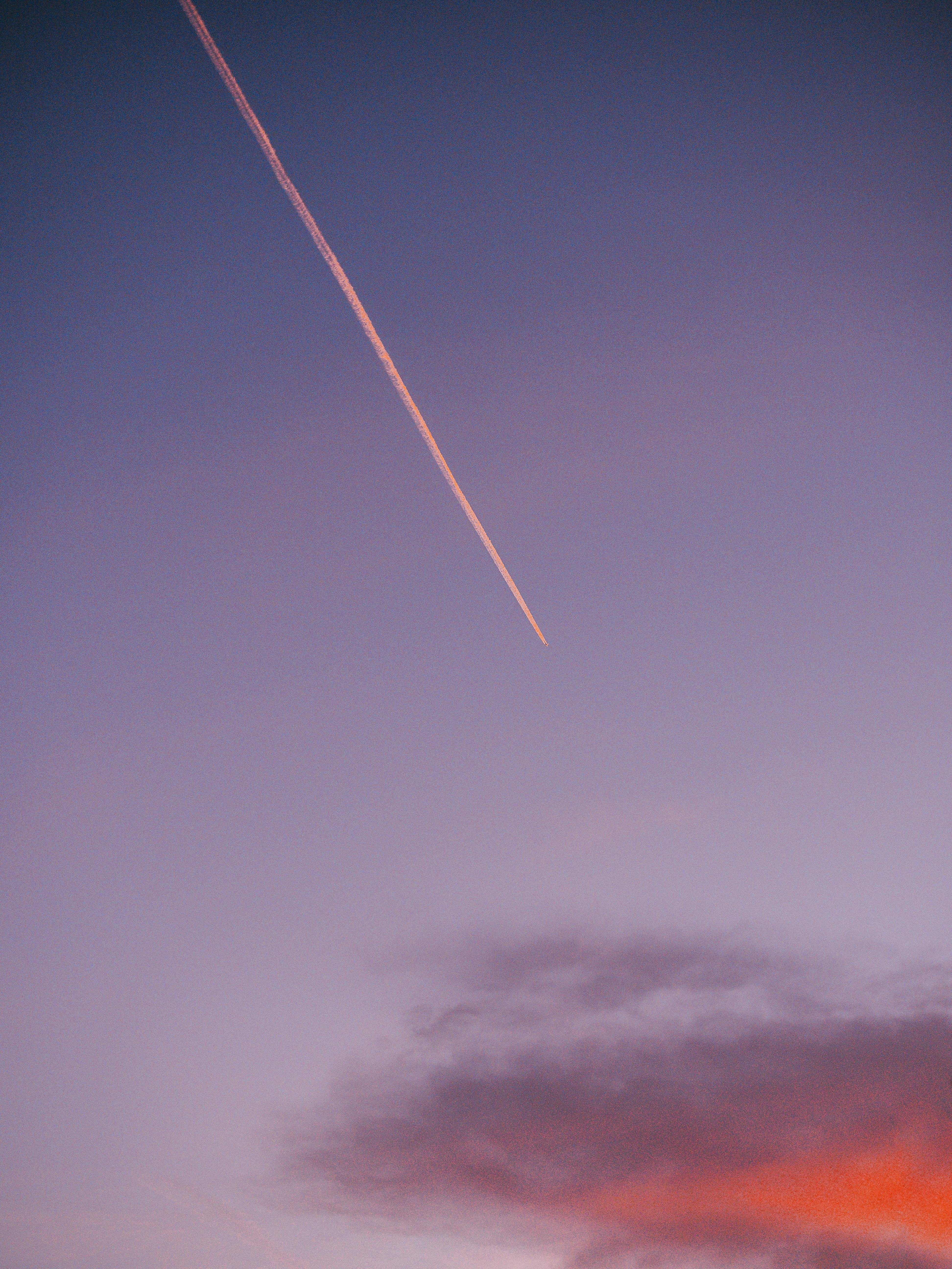 Serene morning sky with a vapor trail and clouds at sunrise. Perfect for peaceful and travel themes.