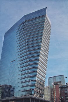 A striking modern skyscraper with reflective glass facade in downtown Milan, showcasing contemporary architecture.