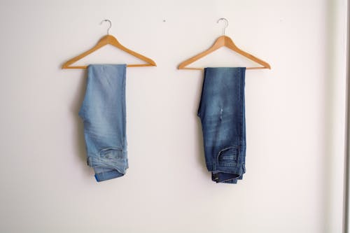 Две развешанные синие штаны и синие джинсы