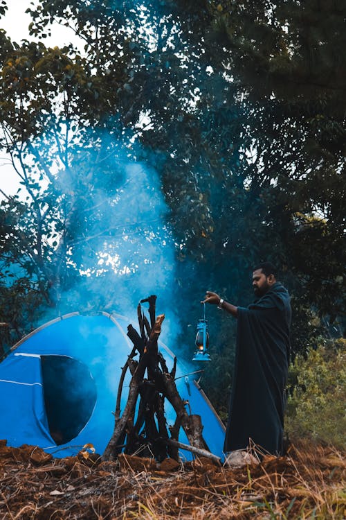 Man Standing by the Fire and Holding an Oil Lamp 