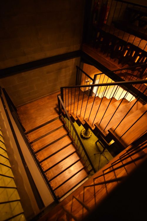 Free A modern wooden staircase with artistic railings in an indoor setting, captured from above. Stock Photo
