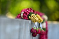 彩色花卉花环，点缀着玫瑰和珠子，悬挂在户外的混凝土墙上