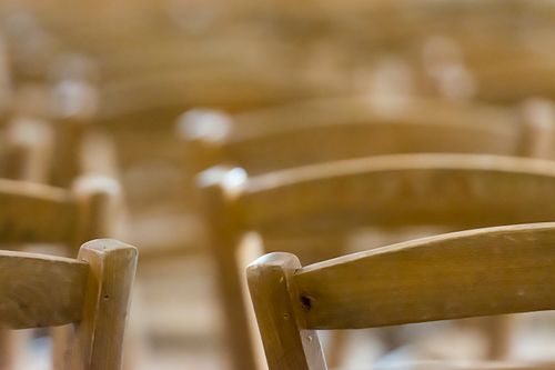 Free Artistic close-up capture of wooden chair backs in soft focus, evoking warmth and simplicity. Stock Photo