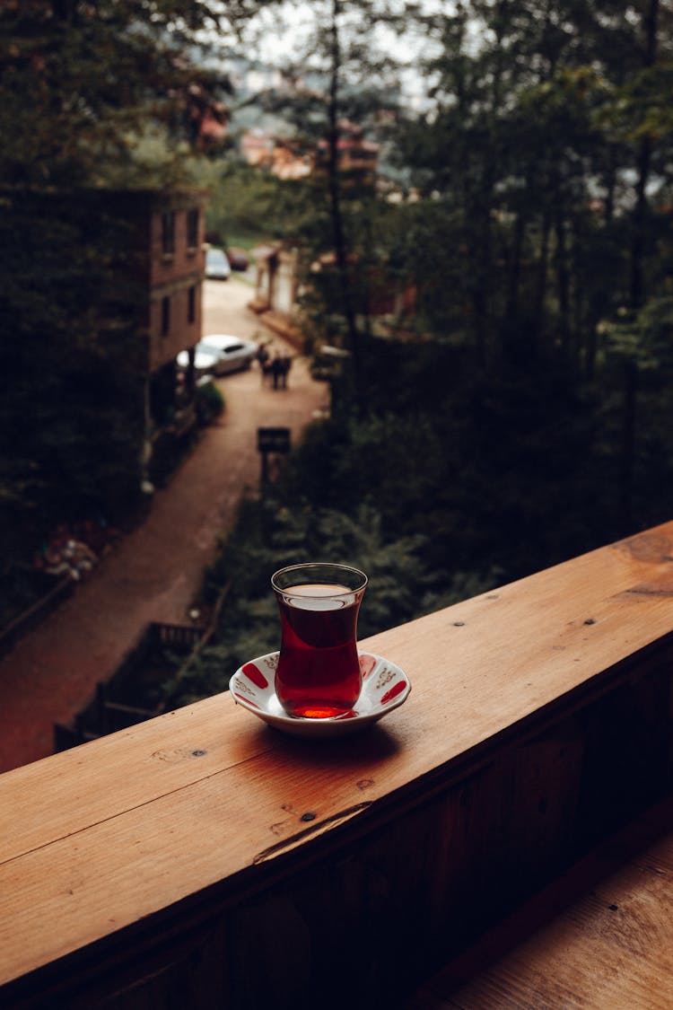 Glass Of Tea On Wooden Balcony Railing