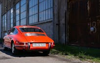 一辆经典的红色古董车停在旧城仓库附近