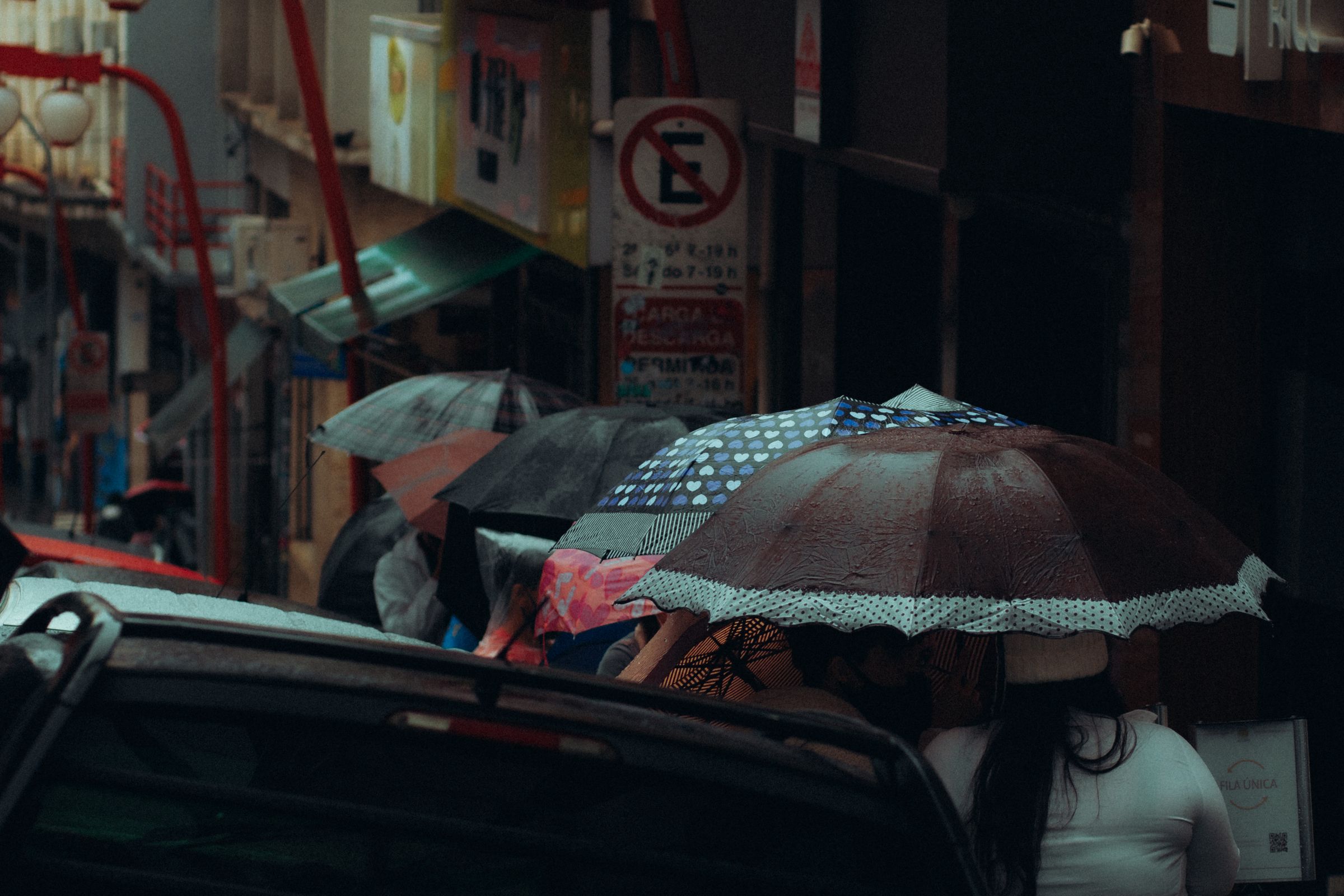 People walking down a rainy London street with umbrellas in autumn