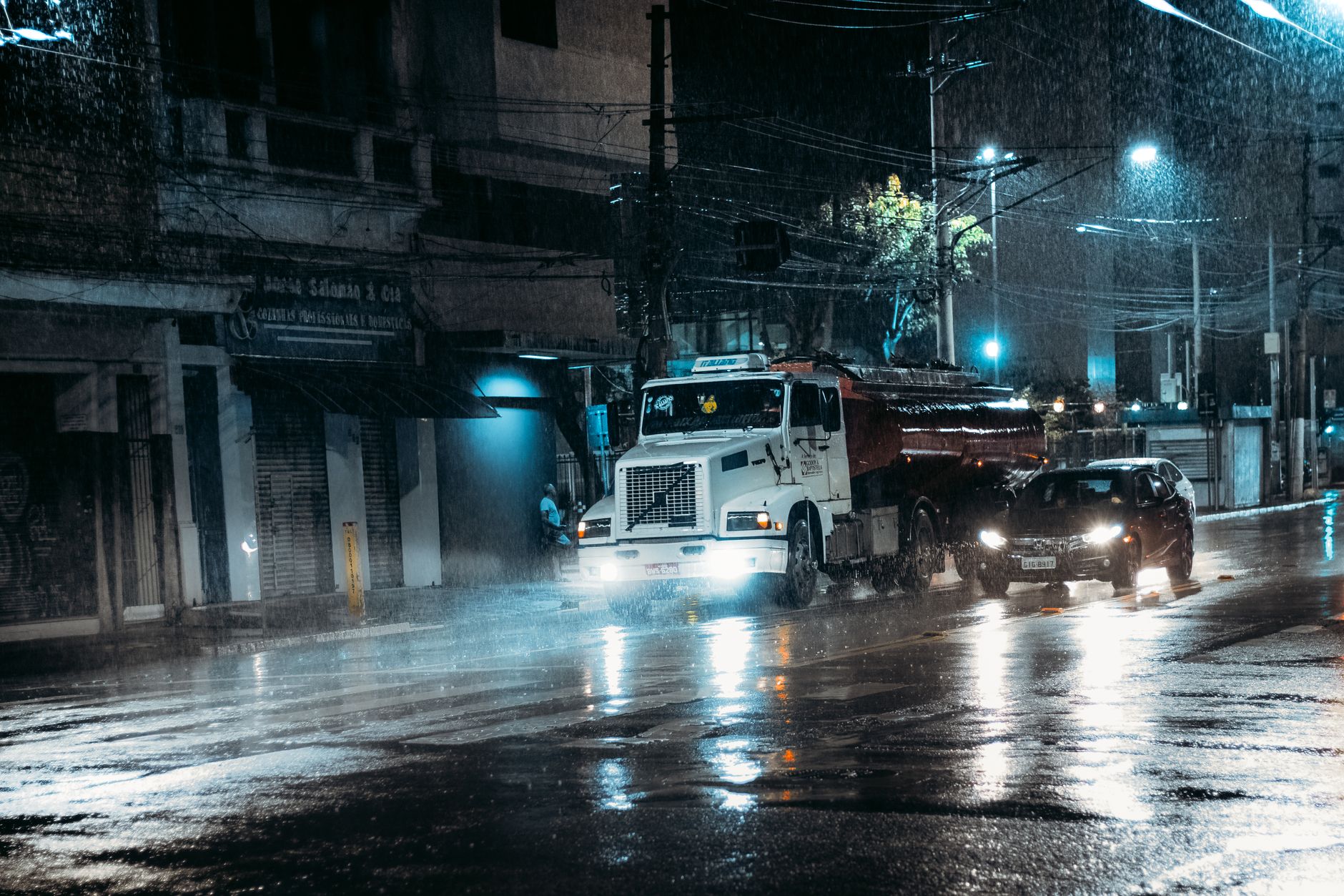 Rain-soaked Nairobi road with vehicles moving slowly through standing water