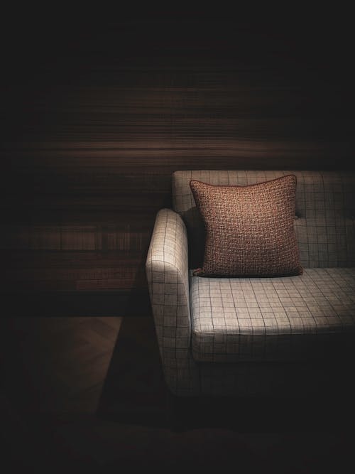 A Sofa Chair with Brown throw Pillow