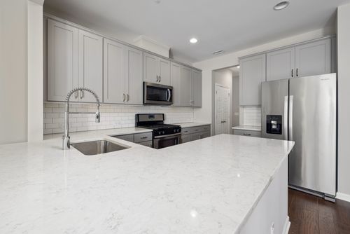 Free Spacious kitchen featuring stainless steel appliances and sleek countertops. Stock Photo