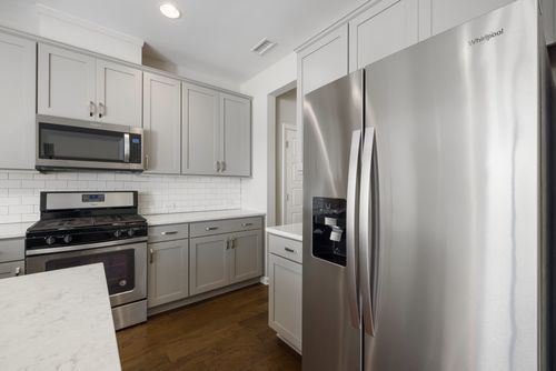 Free Sleek modern kitchen featuring stainless steel appliances and white cabinetry for a contemporary look. Stock Photo