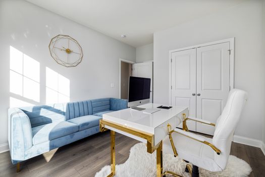 Bright home office interior featuring a modern sofa, sleek desk, and stylish decor.