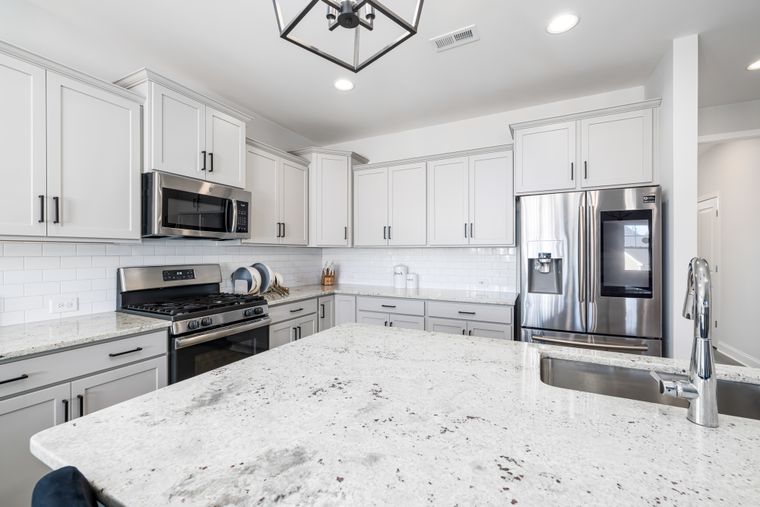Bright modern kitchen with a granite countertop and stainless steel appliances