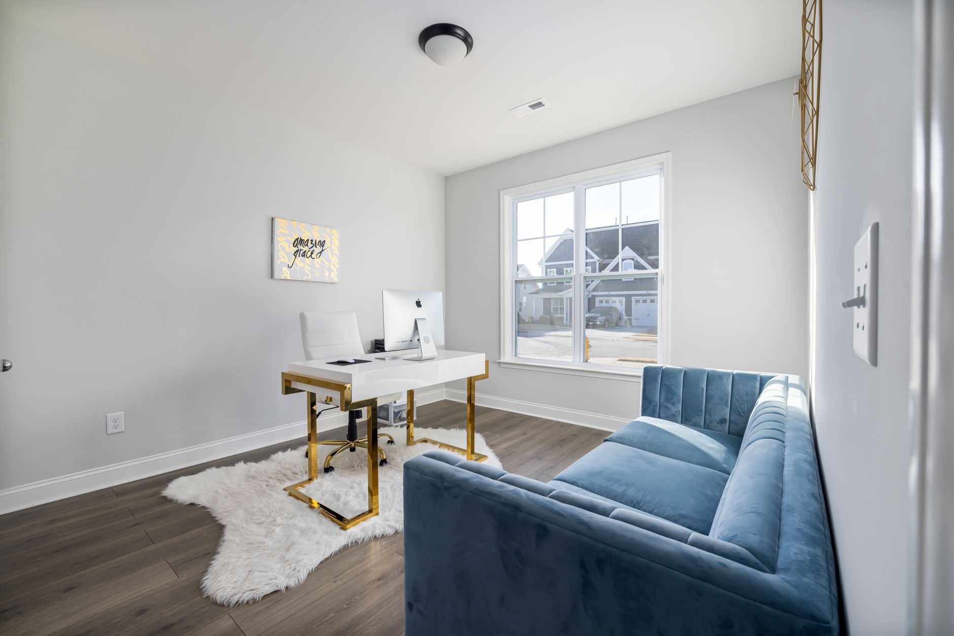 quiet luxury home office inspiration for small spaces A stylish modern home office featuring a velvet couch and sleek desk with natural light.