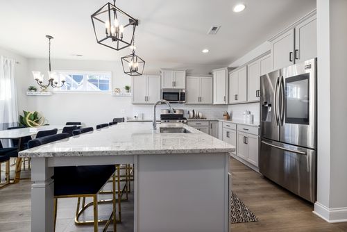 Free Contemporary kitchen with marble countertops and stainless steel appliances, showcasing elegance and space. Stock Photo