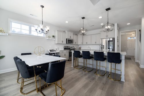 Black Chairs by White Table and Kitchen Island