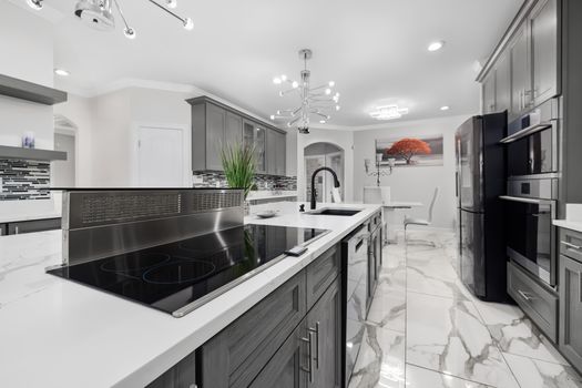 Sophisticated kitchen design featuring a sleek island, marble floors, and chic lighting.