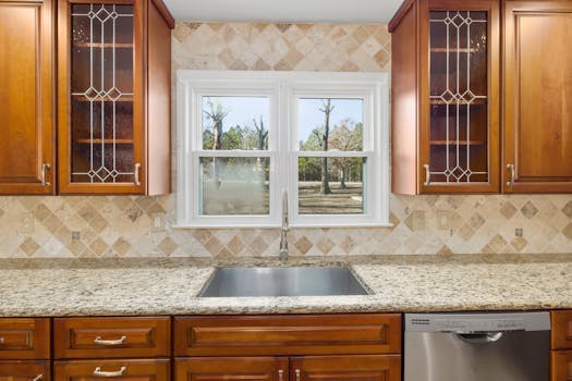 Sleek kitchen interior featuring wooden cabinets and a central window view.