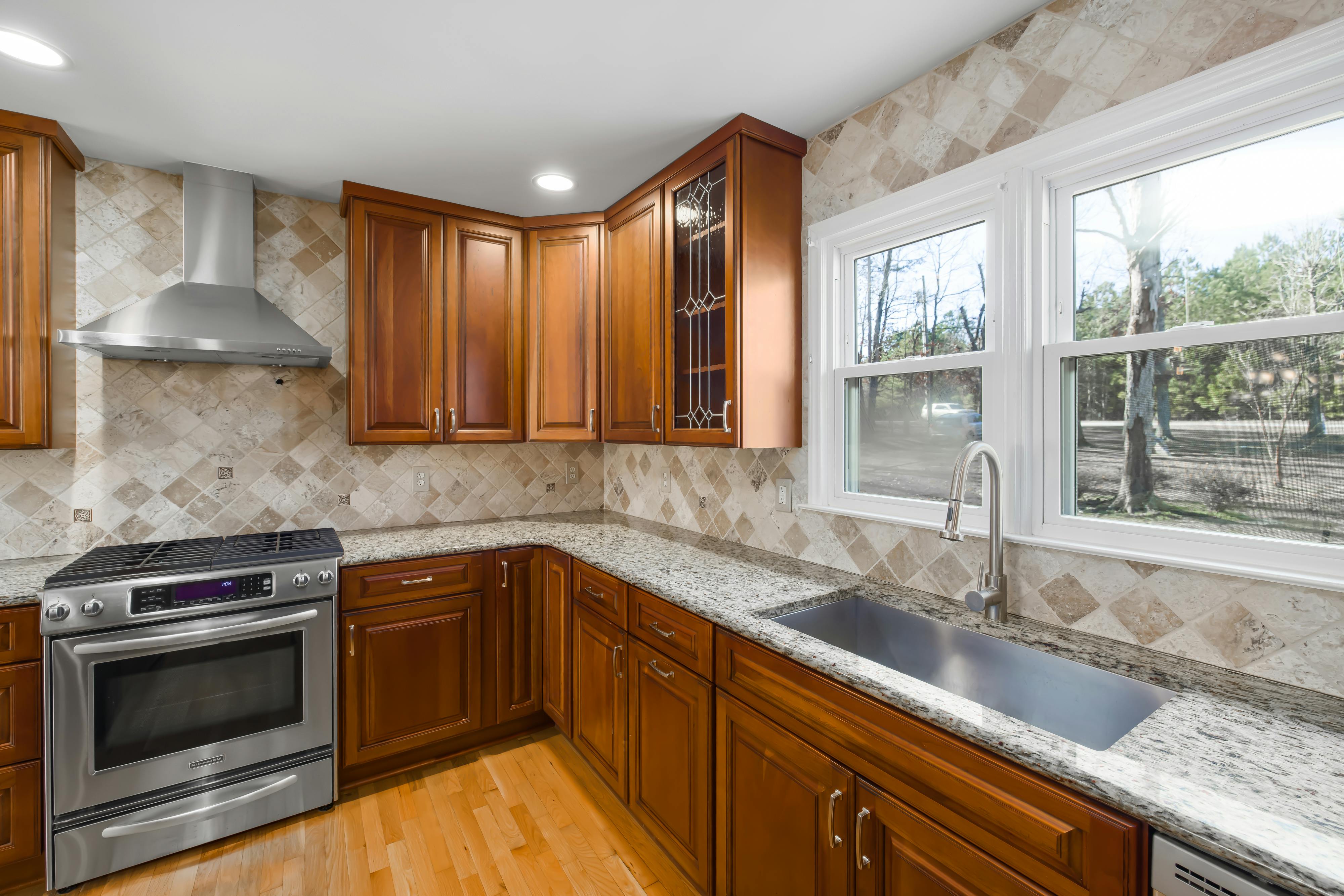 Spacious kitchen with granite countertops and natural light from large windows.