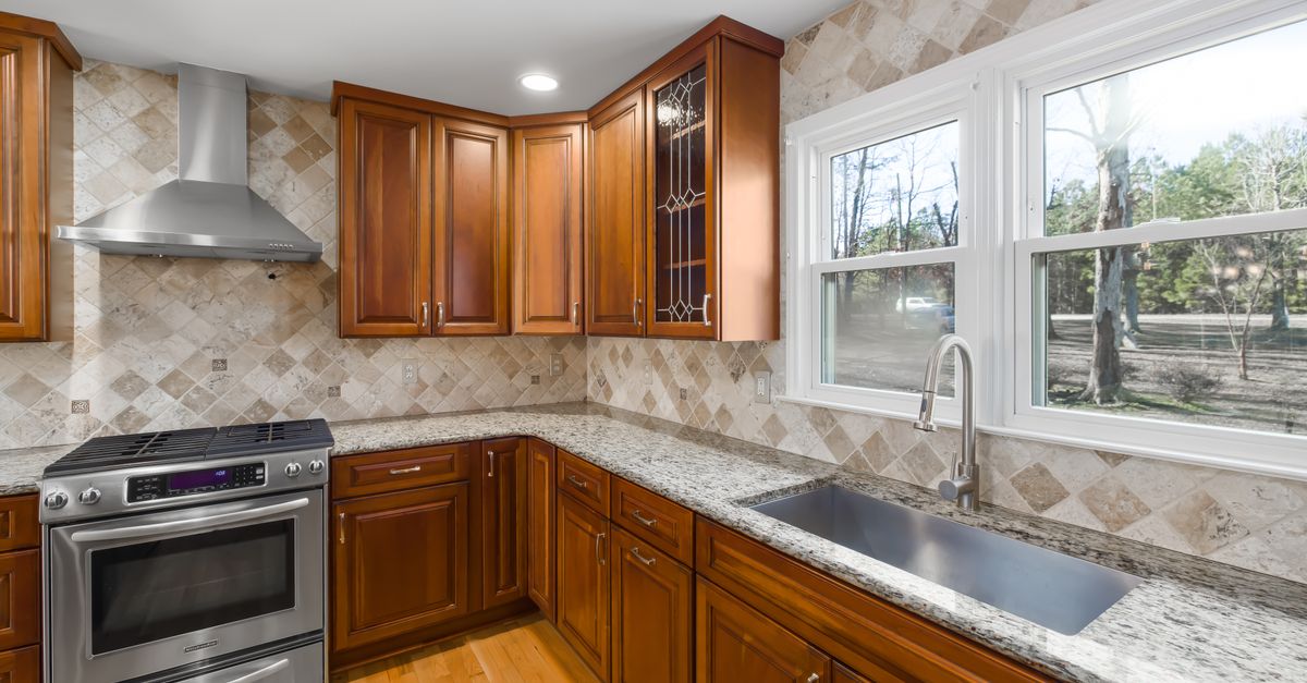 Spacious kitchen with granite countertops and natural light from large windows.
