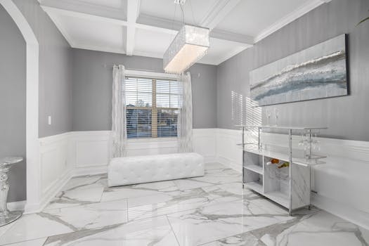 Bright minimalist room with luxury marble flooring and modern decor, featuring chandelier and abstract art.