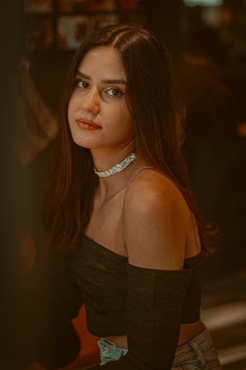 A Portrait of a Young Woman in a Black Off Shoulder Top