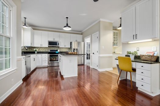 Spacious contemporary kitchen with wooden flooring and modern design elements. Ideal for home decor inspiration.