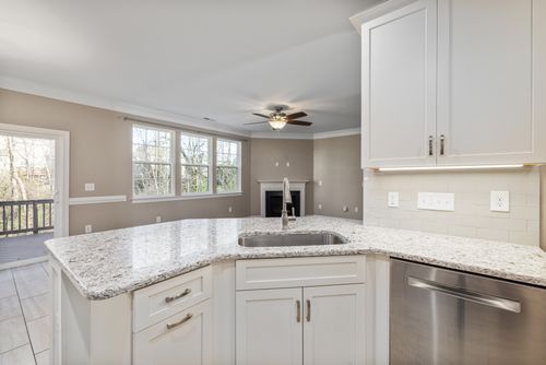 Free Spacious kitchen interior with white cabinets and granite countertops, featuring stainless steel appliances. Stock Photo