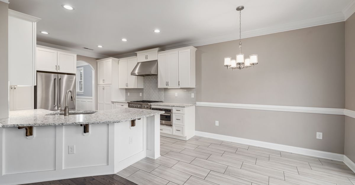 Bright modern kitchen with granite island and stainless steel appliances.