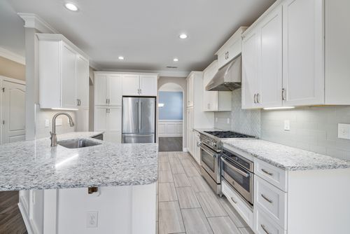 Free A sleek, modern kitchen with white cabinetry and stainless steel appliances showcasing minimalist interior design. Stock Photo