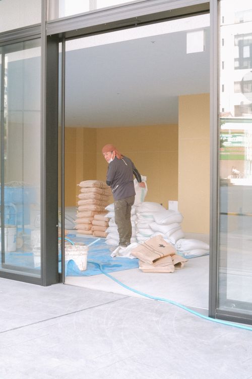 Free A construction worker organizing cement bags indoors during a renovation project. Stock Photo