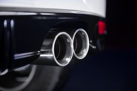 Detailed view of a chrome twin exhaust on a modern vehicle.