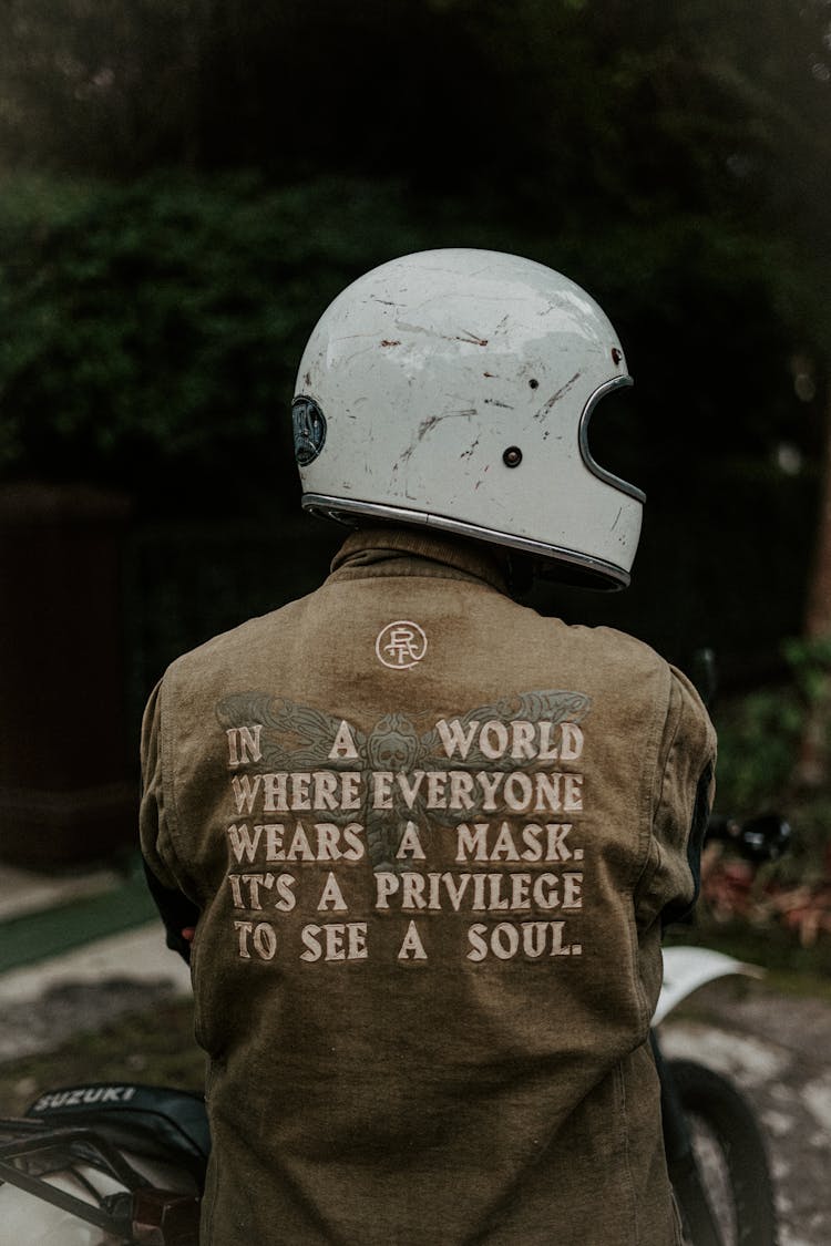 Person Wearing Helmet In Jacket With Inspirational Message